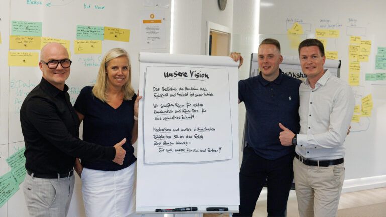 Oculus Concept Workshop-Team präsentiert mit Daumen hoch das gemeinsam erarbeitete Unternehmensleitbild