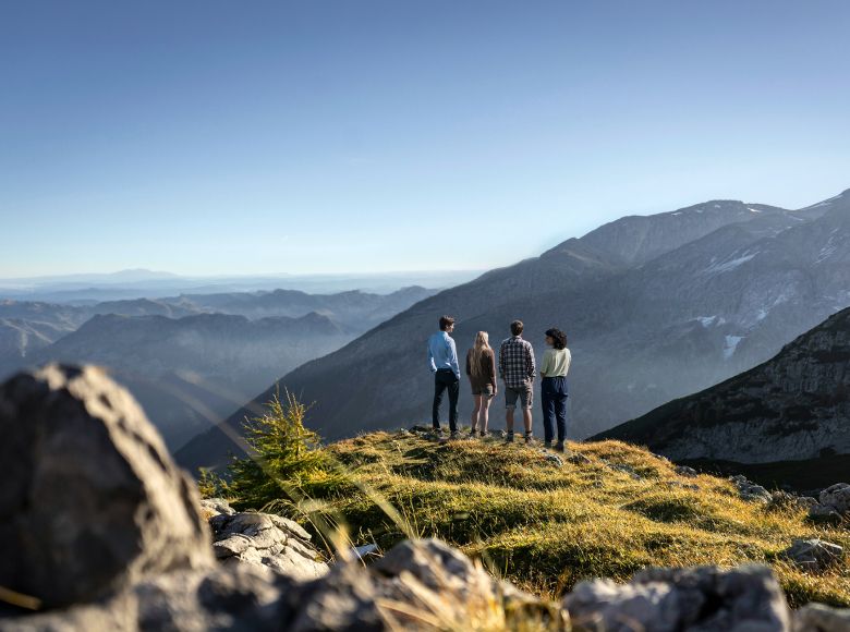 Wanderer blickt vom Gipfel über die Berglandschaft – Symbolbild für Weitblick und Erfolg zum Angebot der Website: Transfomrationsberatung für den Mittelstand